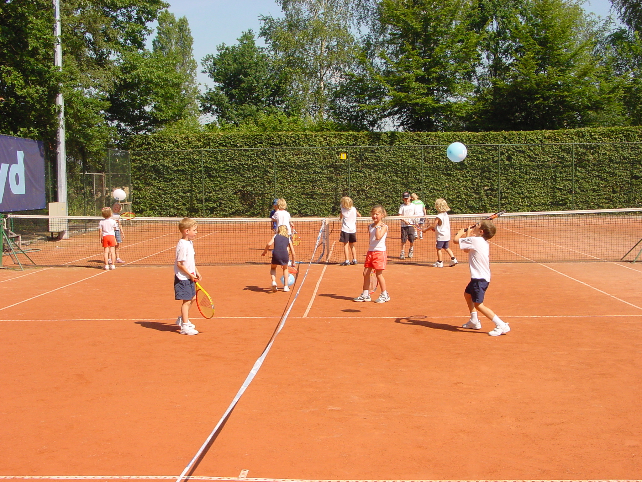 Kinderen spelen tennis tijdens sportkamp