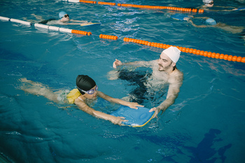 coach-teaching-kid-indoor-swimming-pool-how-swim-dive-swimming-lesson-kids-development